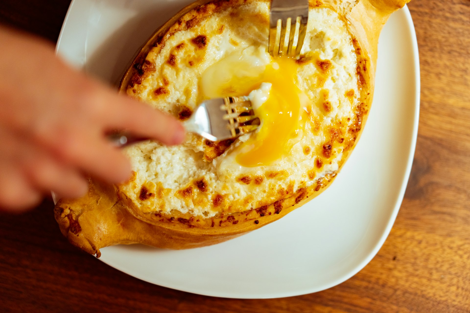 a person holding a fork over a plate of food